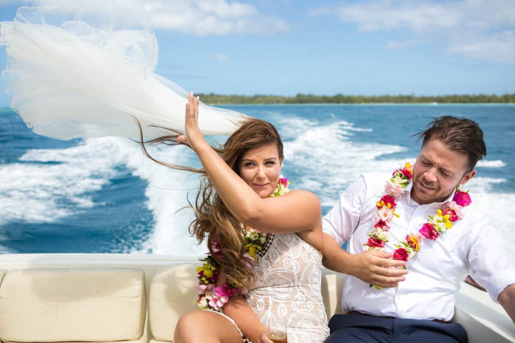 bride on a boat ride back, veil flying in the wind