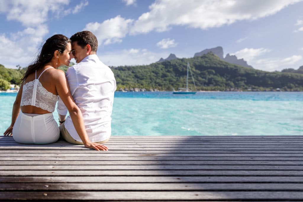 Livia & Marc sitting on the deck of their overwater bungalow