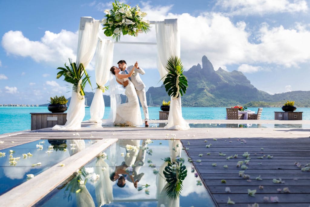 couple kissing under the arch of the lagoon restaurant at st regis resort bora bora