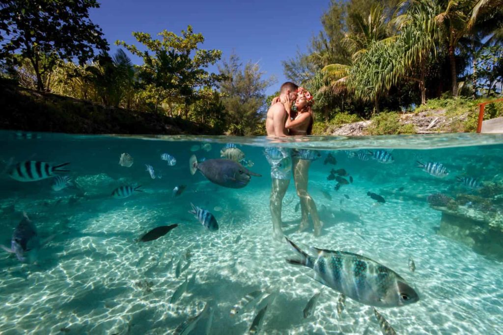 couple inside the water of four seasons Bora Bora lagoon