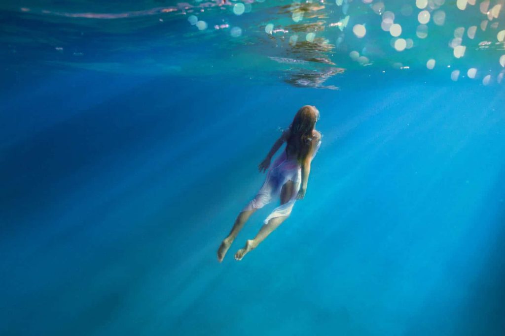 Little girl swimming underwater in the lagoon of Bora Bora